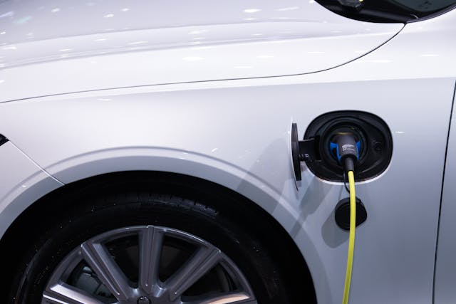 Close-up of an electric car charging port with the cable connected